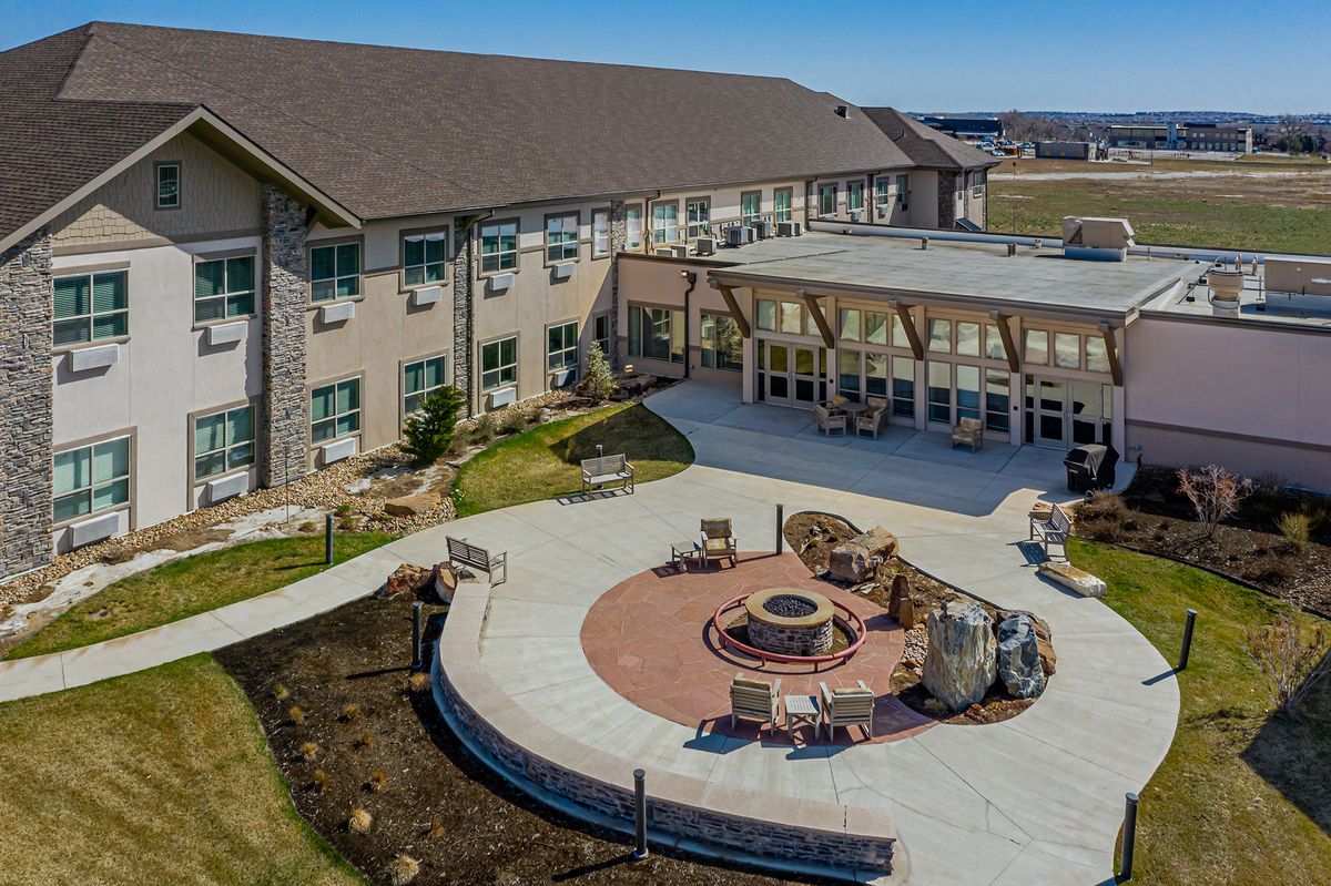 Aerial view of a modern building featuring an outdoor courtyard with seating and a fire pit.