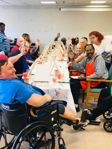 A joyful community gathering where individuals engage in a collaborative painting activity, celebrating creativity and companionship.
