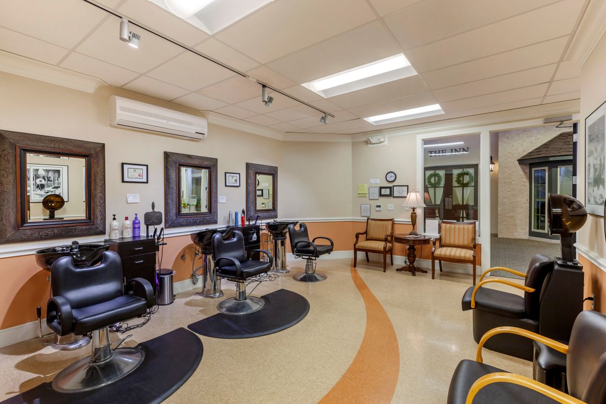 A modern hair salon interior with styling stations and a comfortable waiting area.