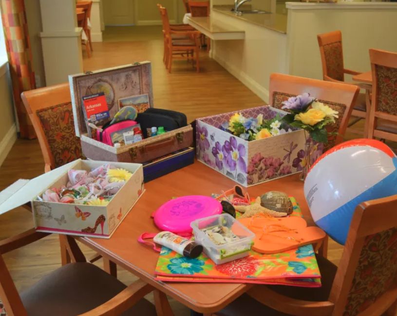 A table filled with various craft supplies, toys, and decorative boxes.