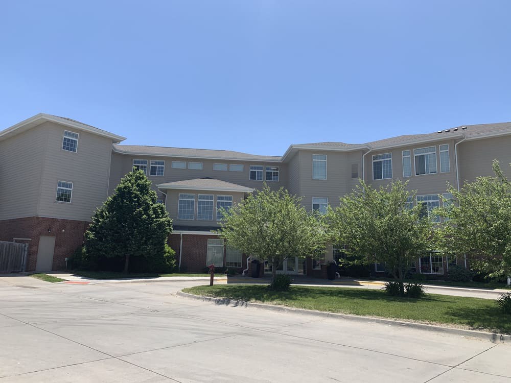 A suburban apartment complex on a sunny day with trees in front.