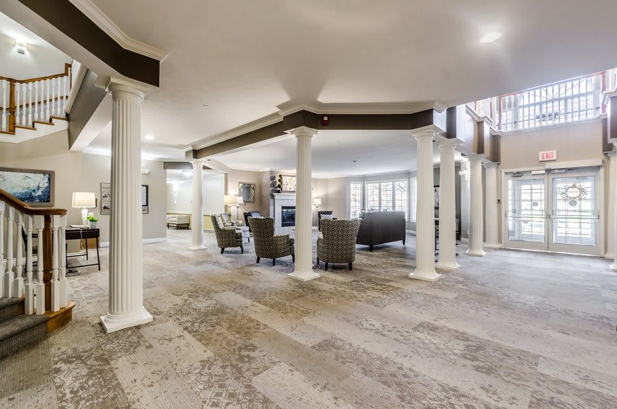 Modern living room with an open layout featuring columns and comfortable seating.