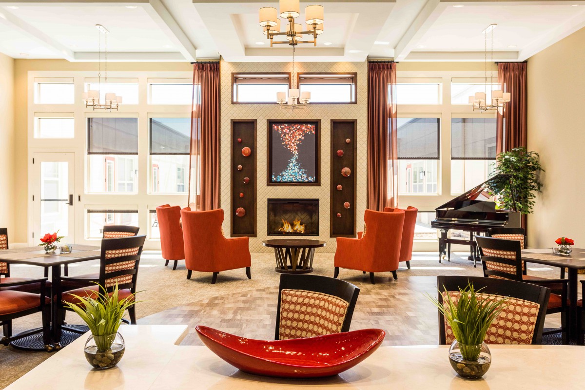 A modern living room featuring a central fireplace, elegant seating, and artistic decor accents.