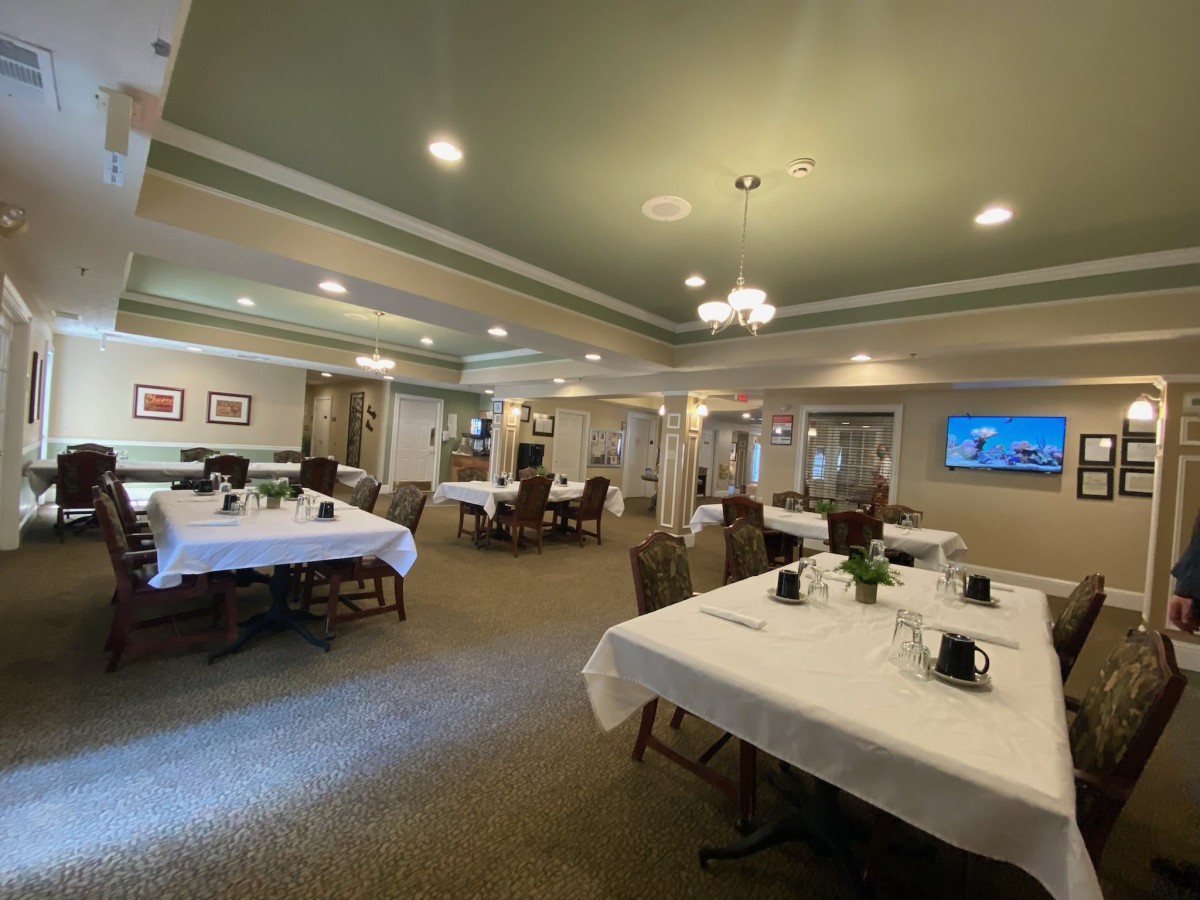 An elegant dining room with neatly arranged tables and a chandelier.