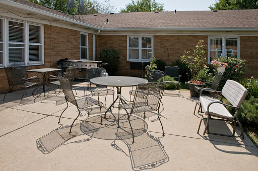 A cozy outdoor patio setup featuring a round table surrounded by metal chairs, perfect for relaxation and gatherings.