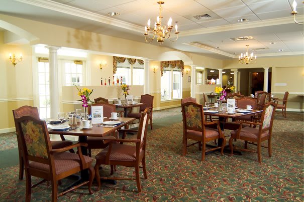 A cozy dining room with elegantly set tables and warm lighting.