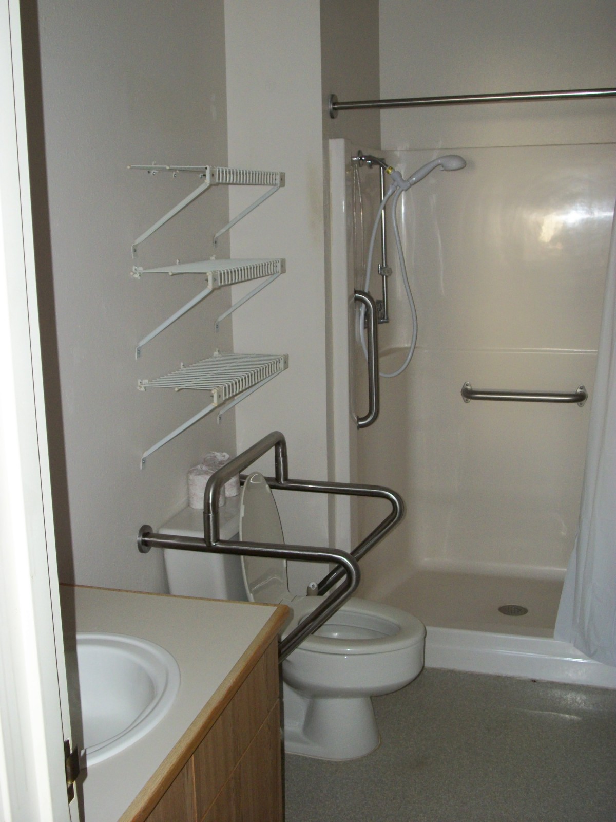Accessible bathroom with grab bars and a walk-in shower.