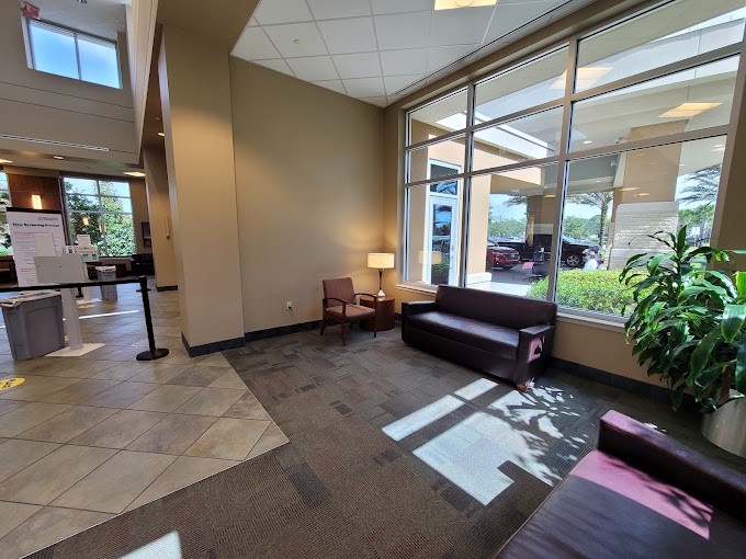A cozy lobby with seating and large windows bringing in natural light.
