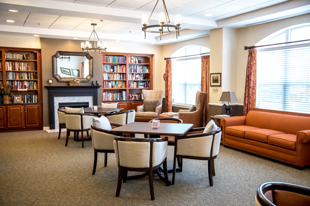 A cozy living room with a seating area, fireplace, and bookshelves.