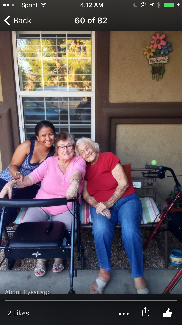 Three women smiling and sitting together on a porch, enjoying a sunny day.