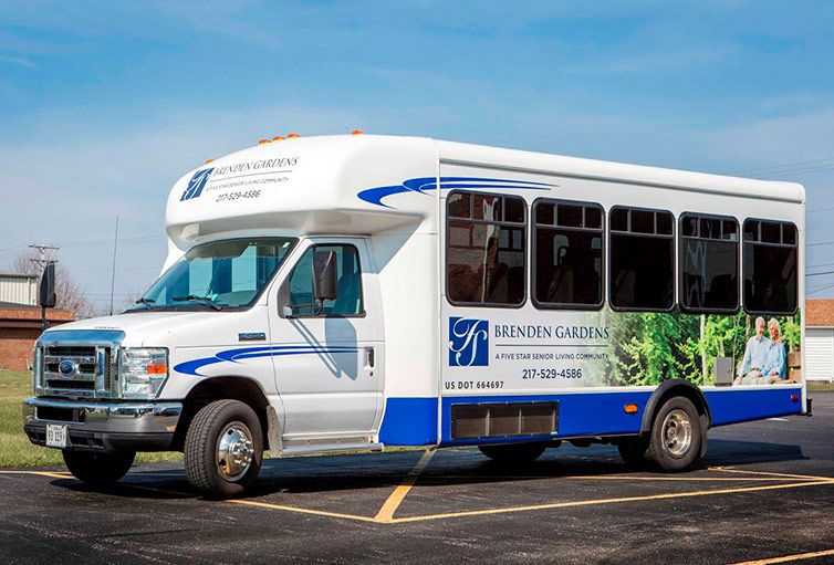 A shuttle bus is parked in a parking lot on a clear day.