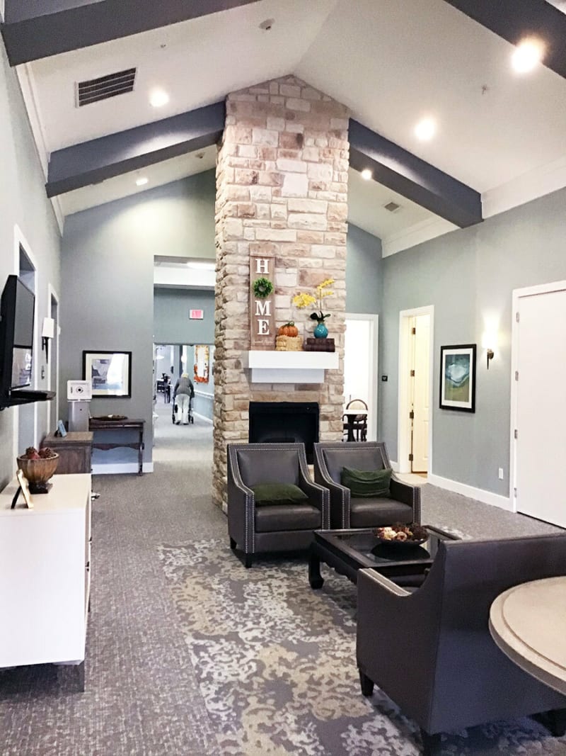 A modern living room with a high ceiling and cozy fireplace.