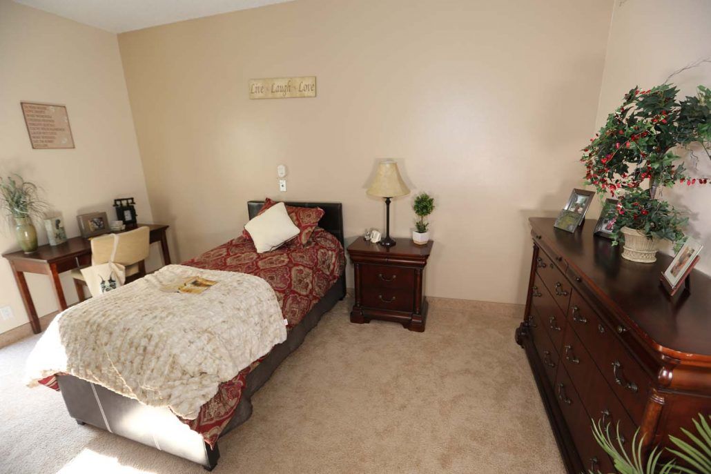 A cozy bedroom with a single bed, nightstand, and dresser.