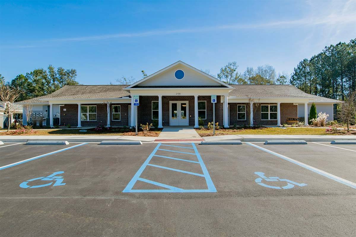 A single-story building with a large entrance and accessible parking spaces in front.