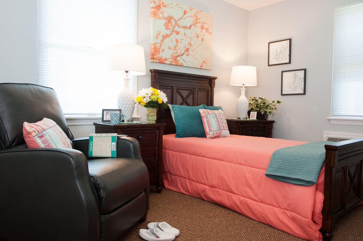 A cozy bedroom with a coral bedspread and matching decor.