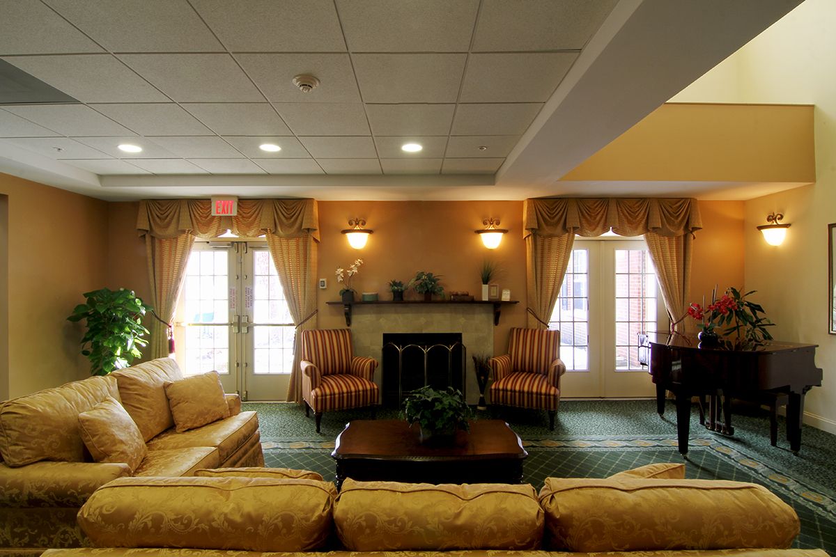 A cozy living room with traditional decor, featuring sofas and a fireplace.