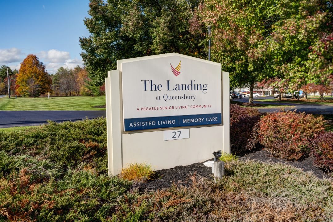 Sign for 'The Landing at Queensbury' indicating assisted living and memory care services.