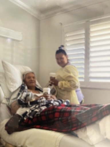 A patient is receiving care from a caregiver in a hospital room.