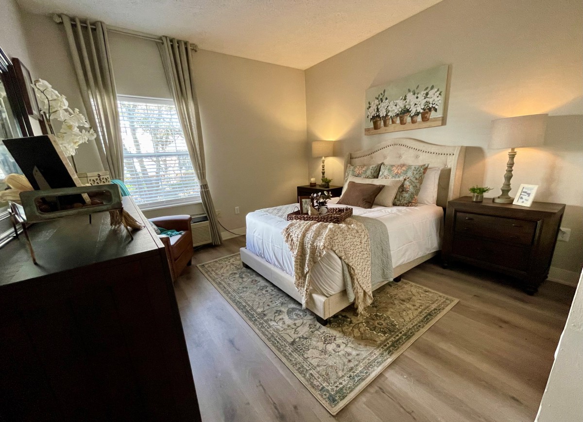 A cozy and elegantly decorated bedroom with a neatly made bed, bedside lamps, and stylish furniture.