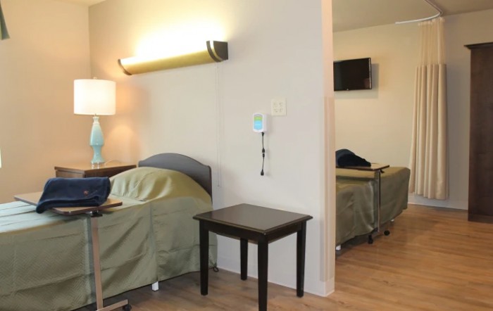 A hospital room with two beds and medical equipment.