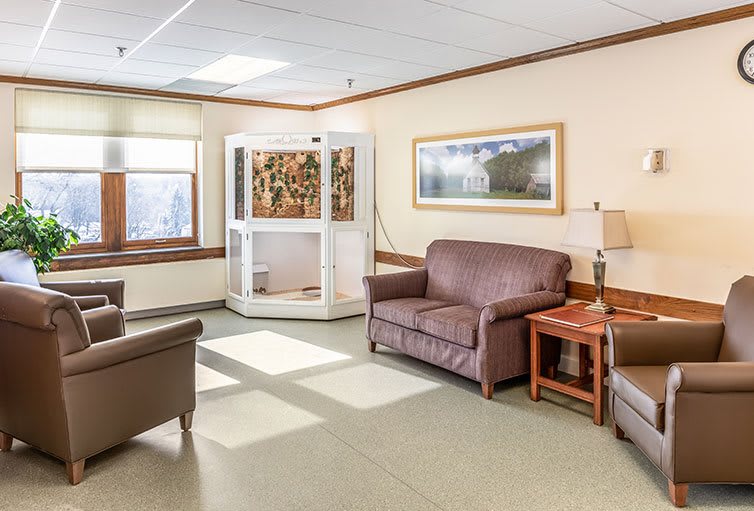A well-lit waiting room with comfortable seating and a large window.