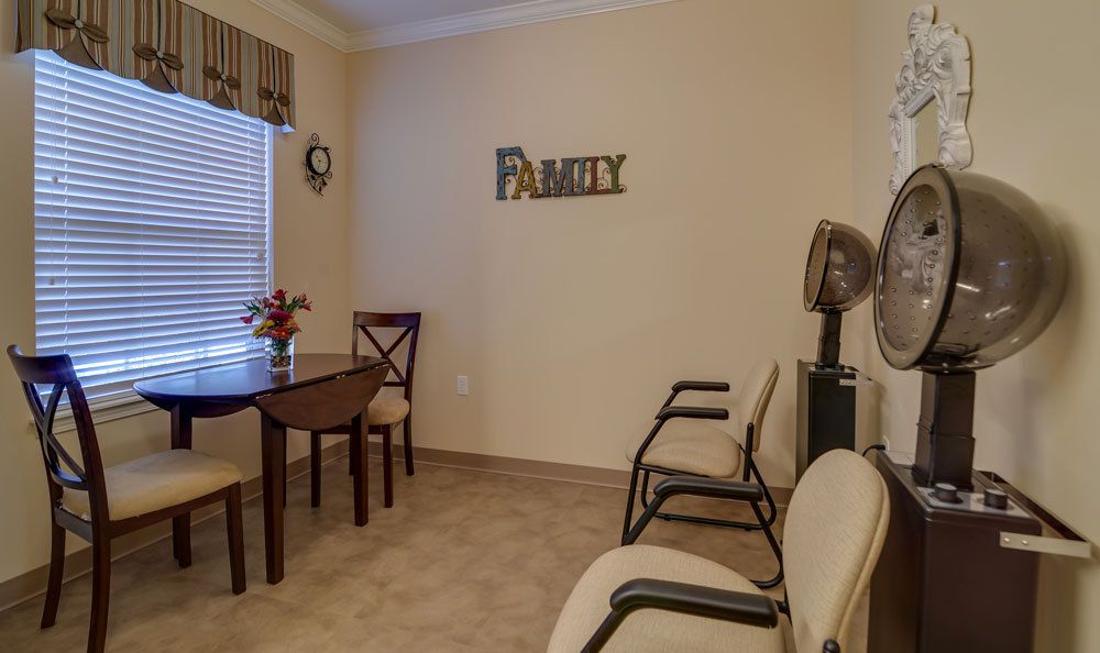 A cozy waiting room with chairs, a table, and wall decor.