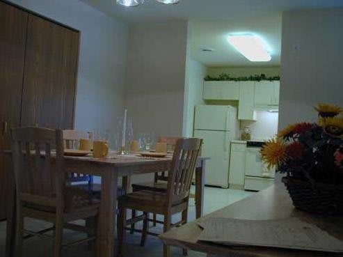 A cozy dining area with a table set for a meal and an adjacent kitchen in the background.