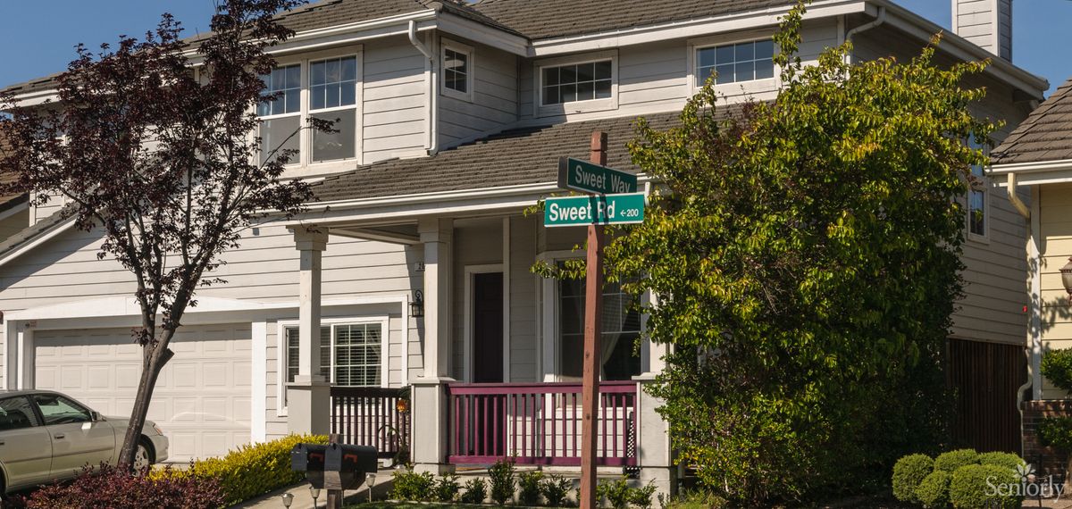 A suburban house with a street sign in front of it.