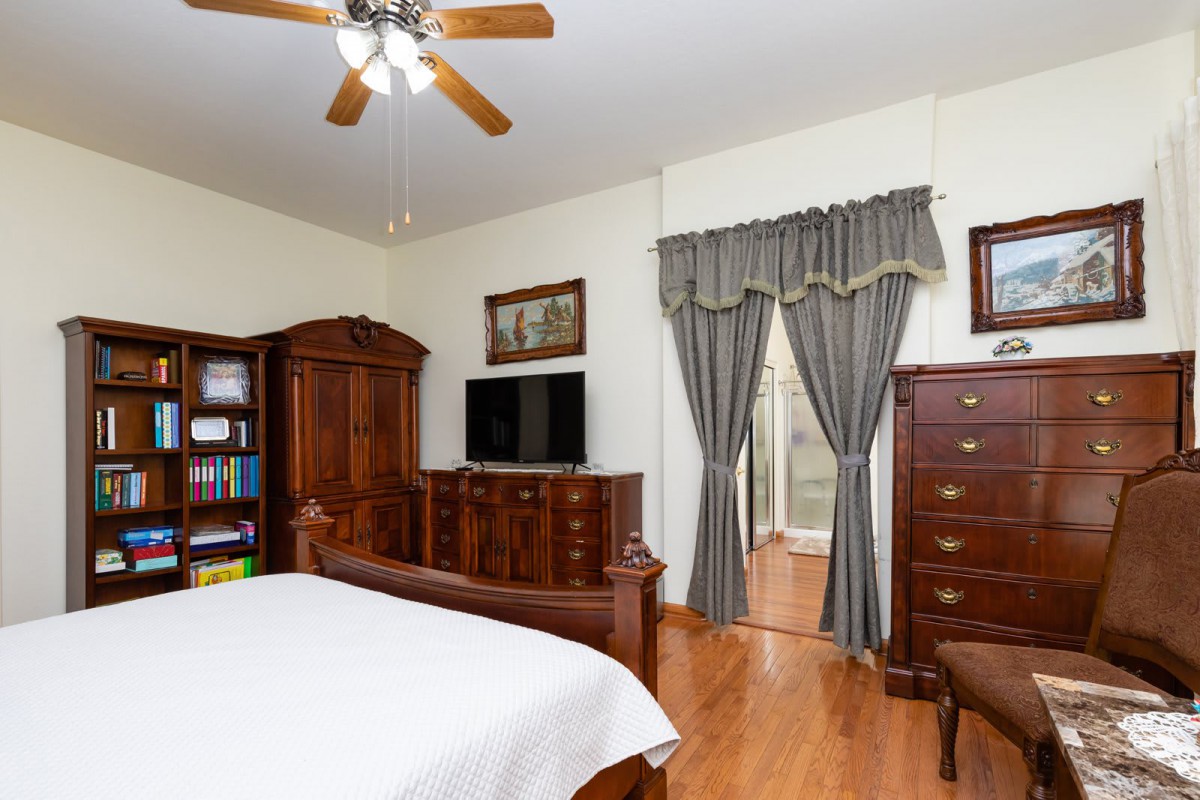 A cozy bedroom with wooden furniture and a television.