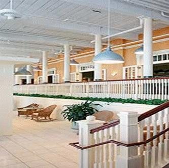 A spacious interior with white columns, seating area, and modern lighting.