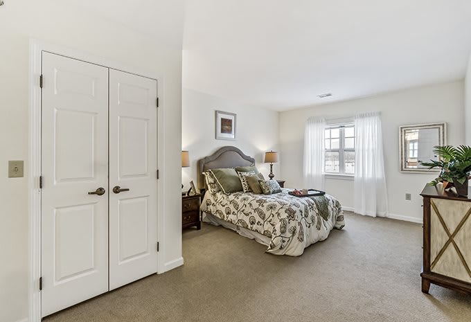 A well-lit bedroom with elegant decor and a carpeted floor.