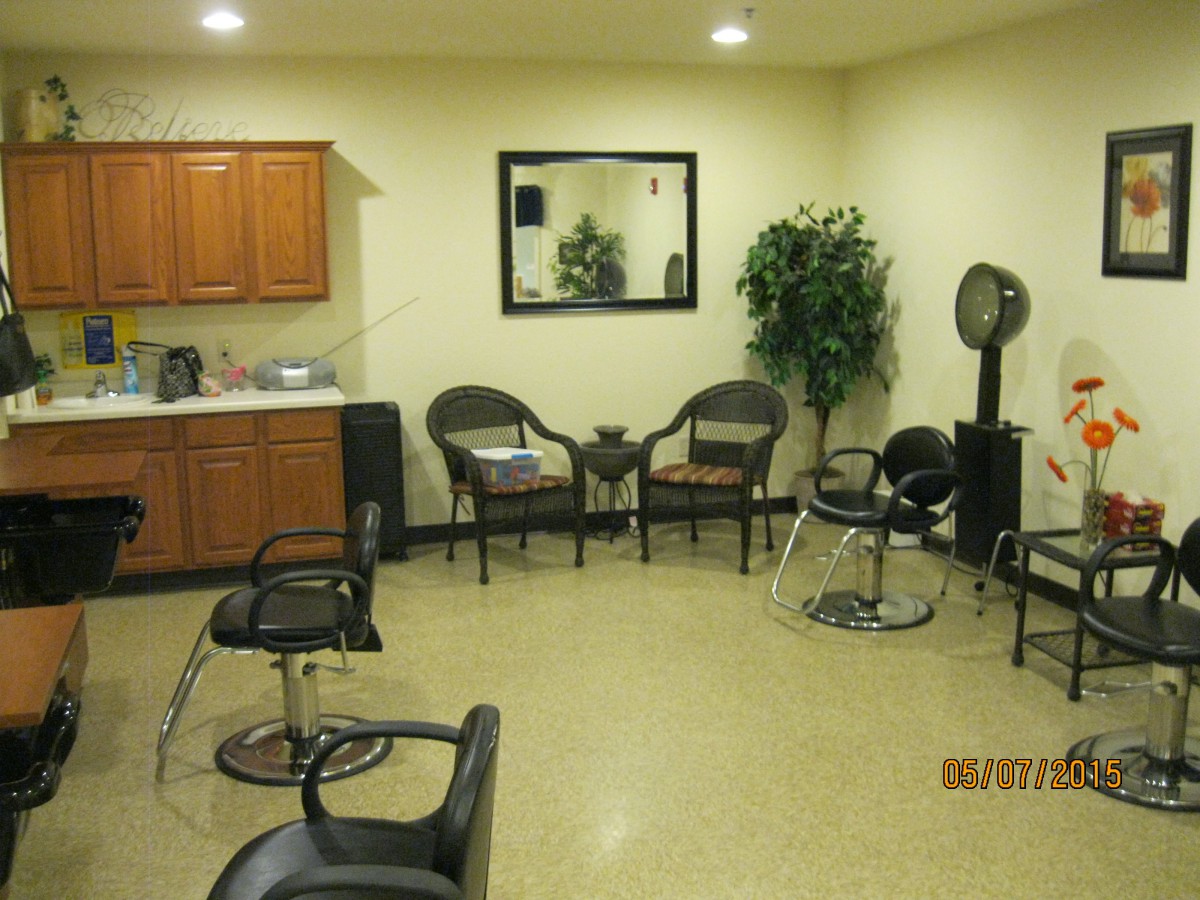 A hair salon interior with chairs, a waiting area, and salon equipment.