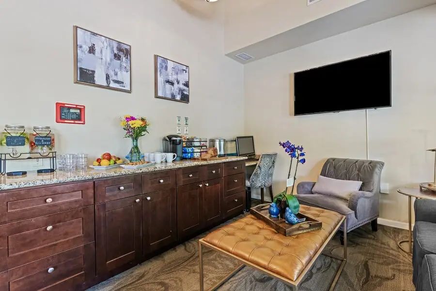 A cozy living room with a sofa, coffee table, cabinets, and wall art.