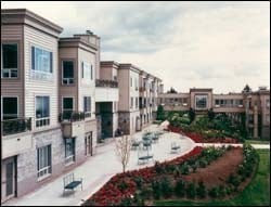 A modern residential building with well-maintained gardens and pathways.