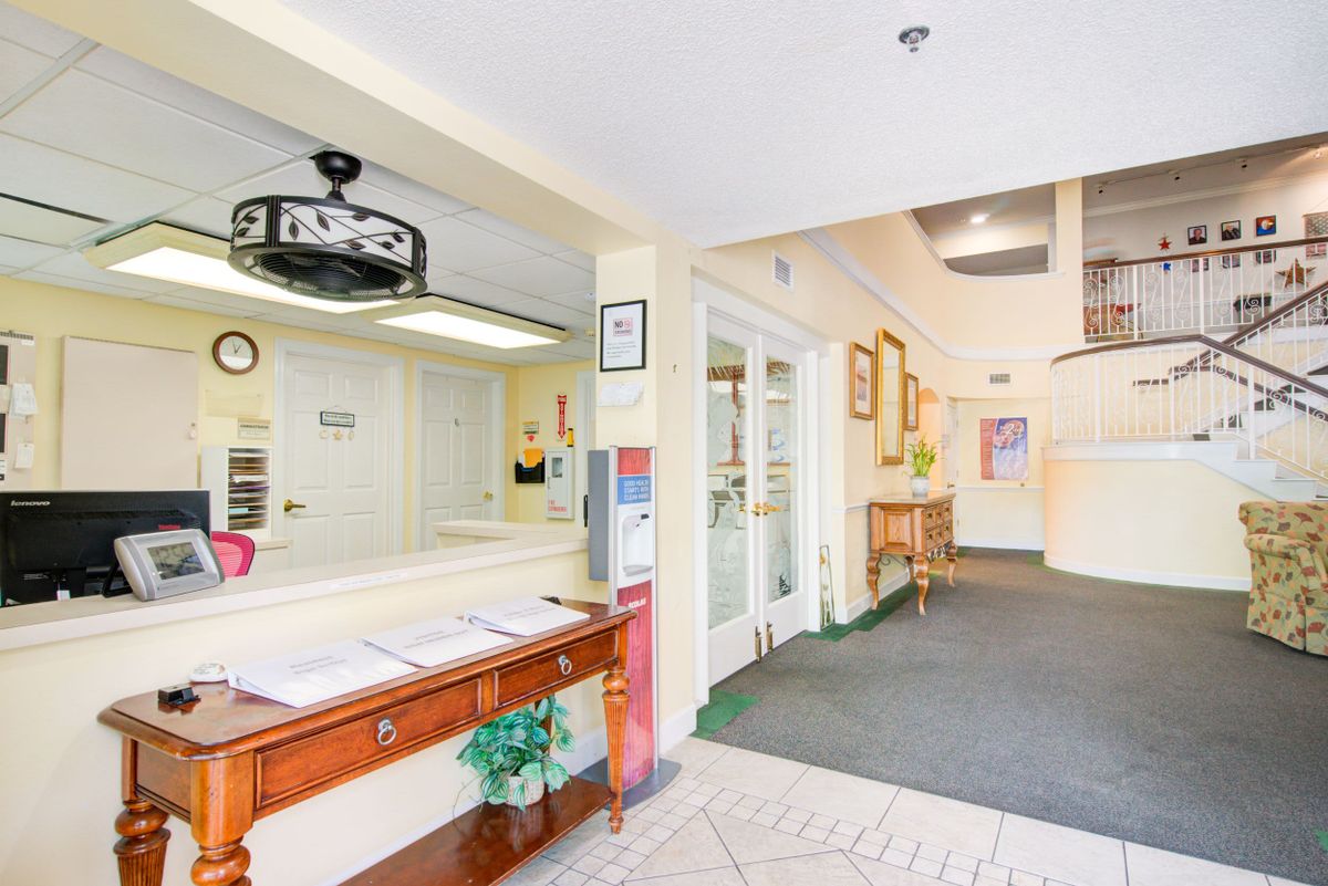 A bright and welcoming reception area with a desk and hallway.
