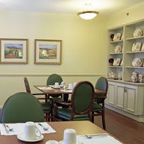 A cozy dining room setup with a table, chairs, and decorative shelves.