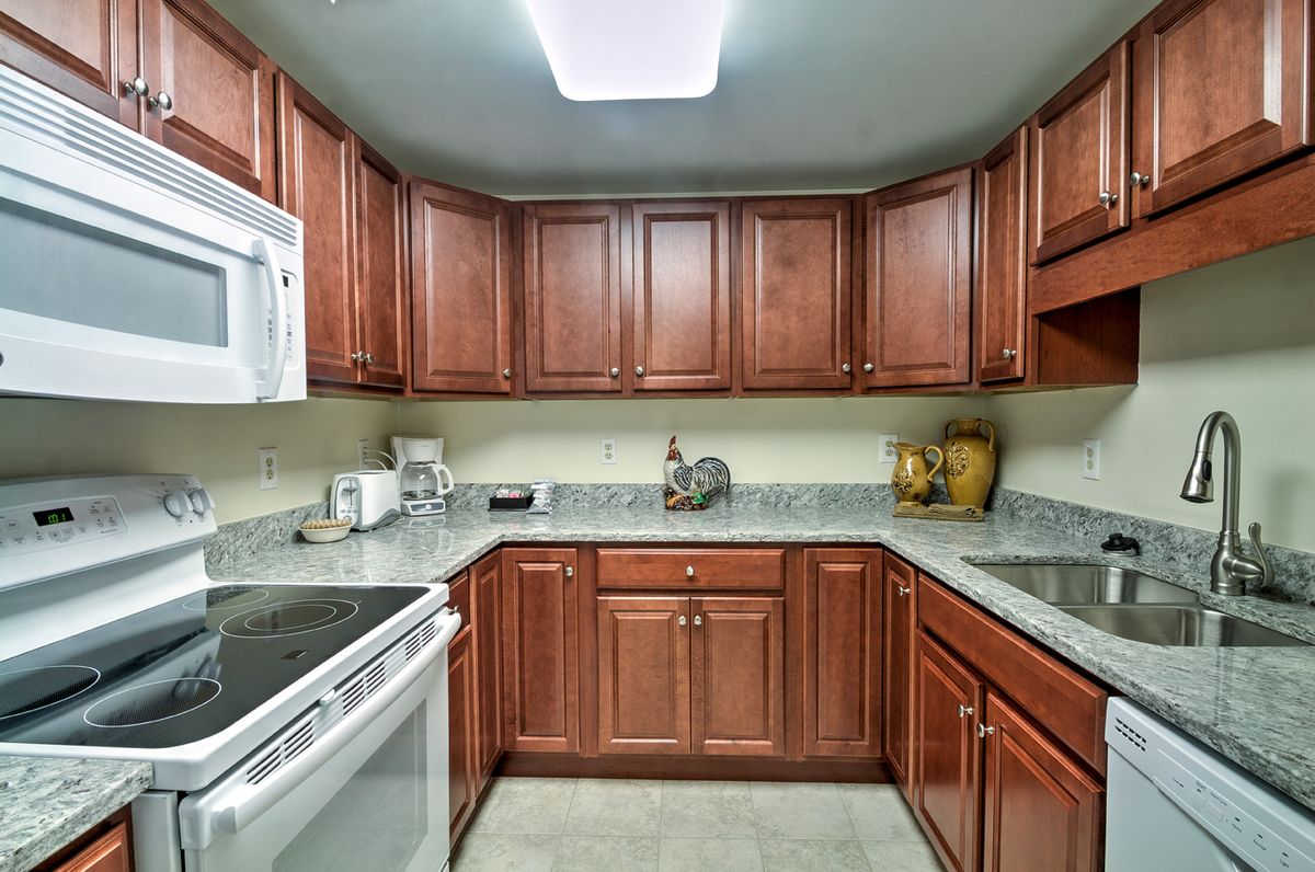 A modern kitchen with wooden cabinets and stainless steel appliances.