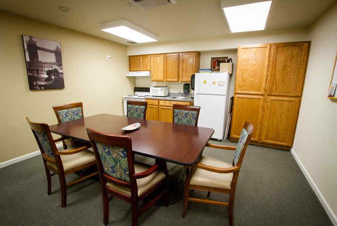 A kitchen and dining area with a table, chairs, and wooden cabinetry.