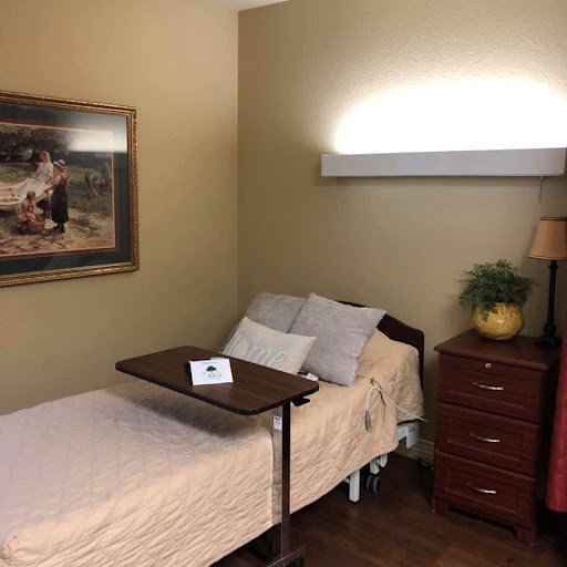 A cozy bedroom featuring a bed with light-colored sheets, a bedside table, and decorative elements.