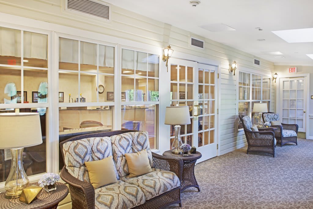 A cozy and well-lit living room area with comfortable seating and large glass doors.