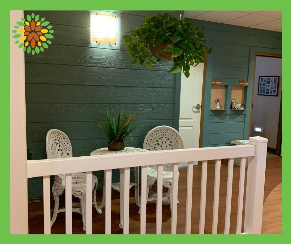 A cozy patio setup with a small table and two chairs, adorned with plants.