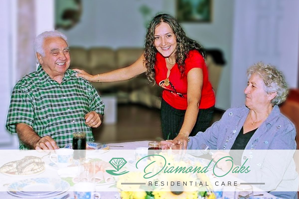 A caregiver interacts warmly with senior residents at a care facility.