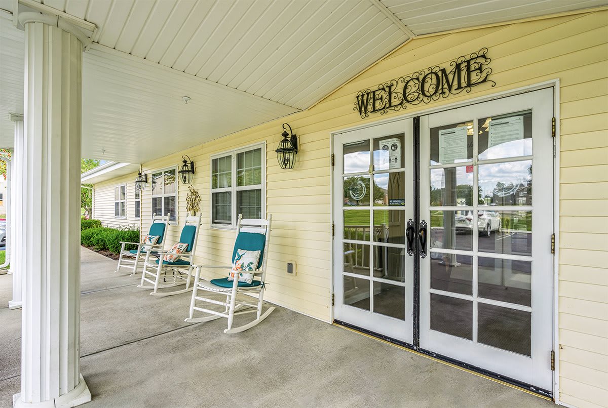 A welcoming entrance with glass doors and rocking chairs on the porch.