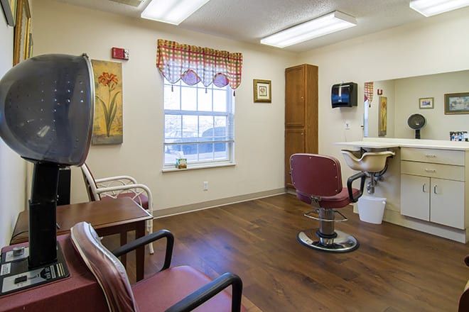 A cozy hair salon interior with chairs, a mirror, and decorative elements.