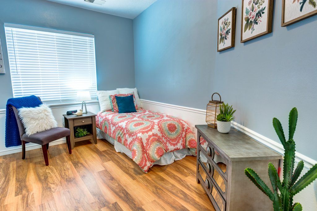 A cozy bedroom with a single bed, blue walls, and decorative elements creating a welcoming atmosphere.