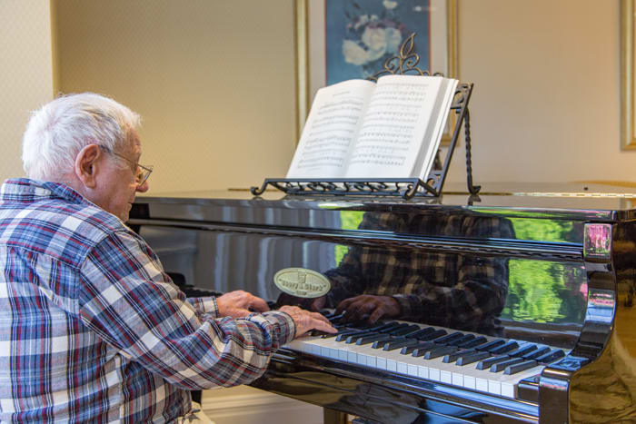 A person playing the piano with sheet music in front of them.