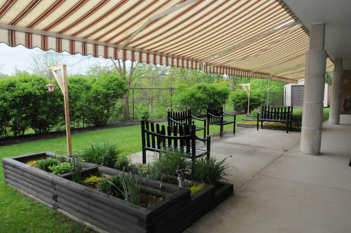 A serene outdoor garden space with seating arrangements and lush greenery.