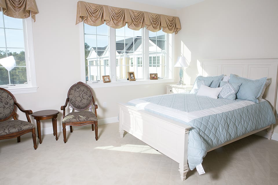 A bright and cozy bedroom with a large window, a comfortable bed, and elegant decor.