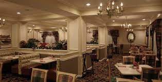A cozy restaurant dining area with elegant chandeliers and neatly arranged tables and chairs.
