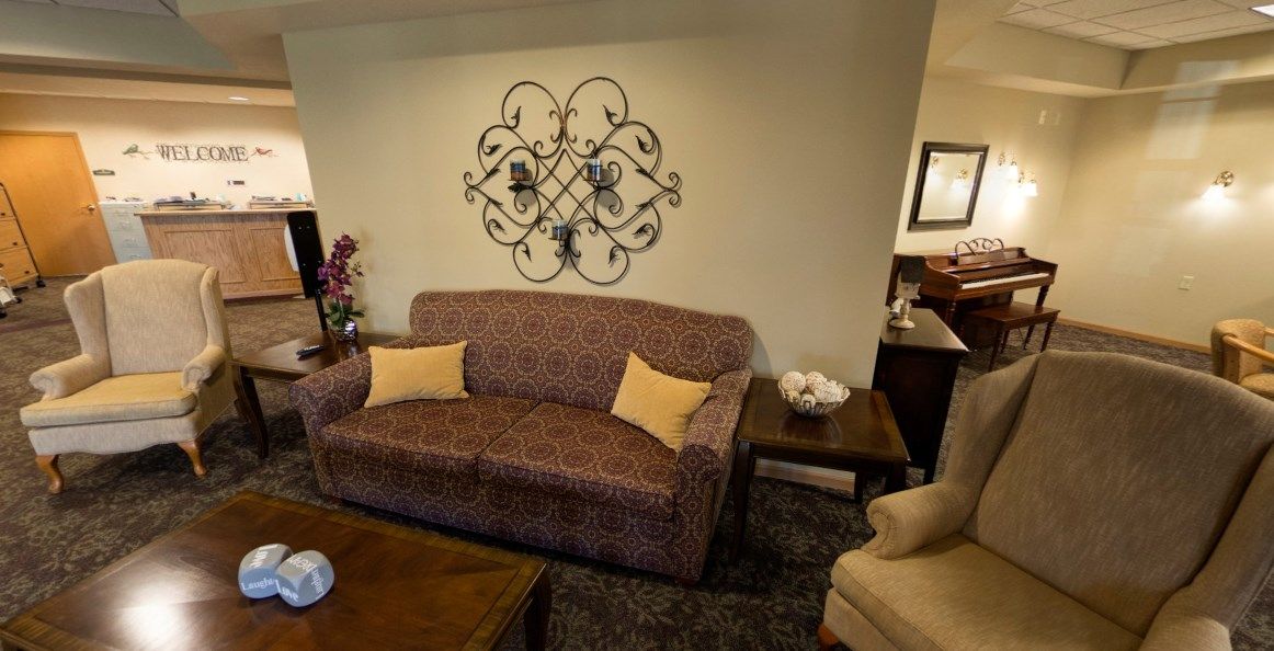 A cozy living room with a patterned sofa, decorative wall art, and a wooden coffee table.